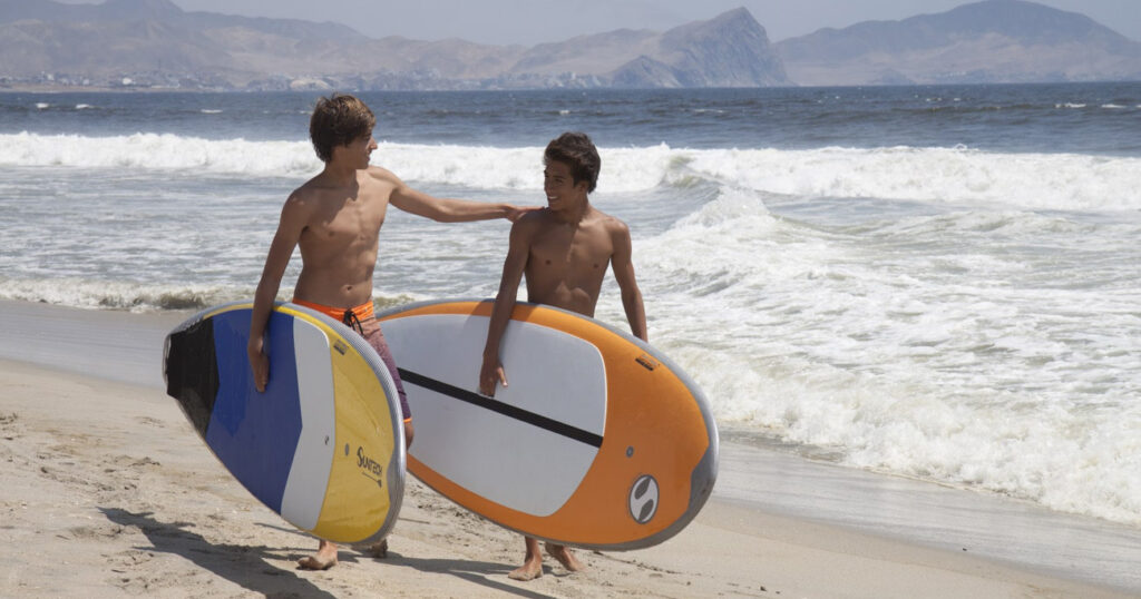 Dos amigos usando paddleboards Sunset